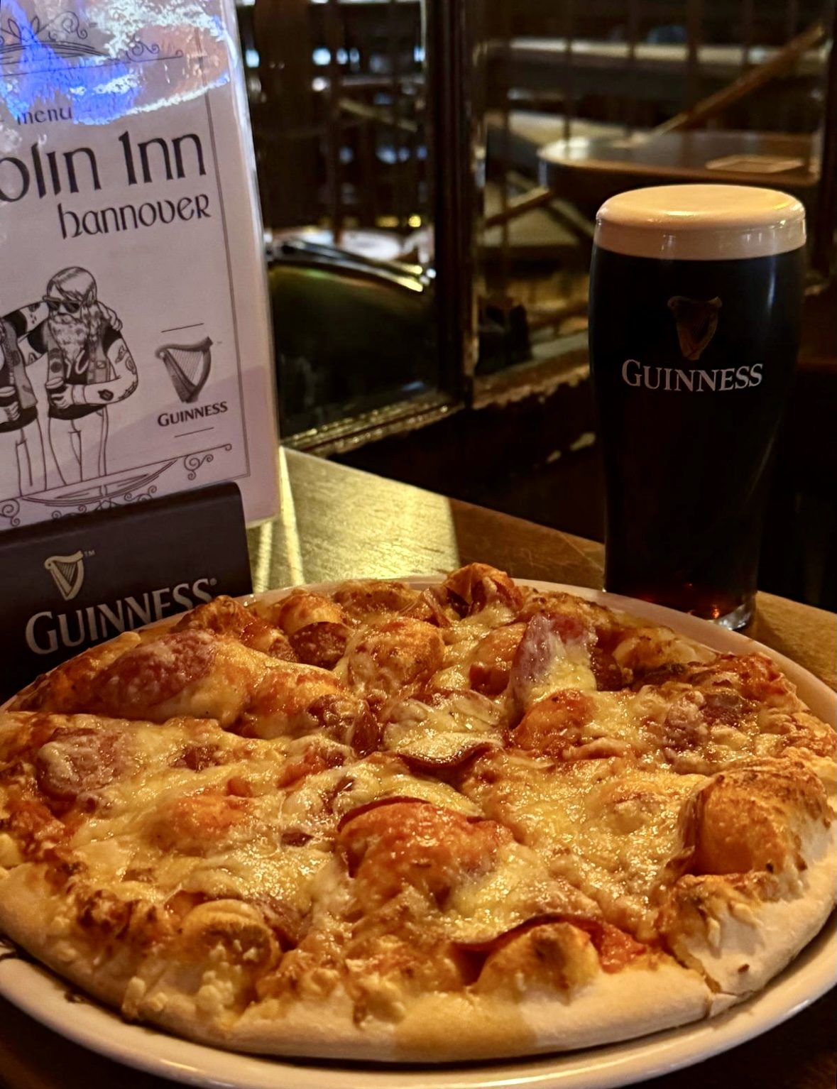 Fresh pizza with a pint of Guinness at Dublin Inn Hannover